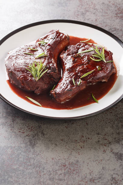 istock Pan Seared Pork Chops with red wine sauce and herbs closeup on the plate. Vertical 1463805524