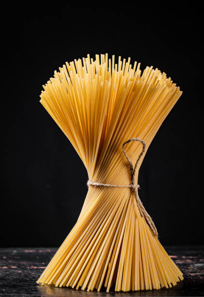 istock A bundle of spaghetti dry tied with a rope stands on the table. 1463808968