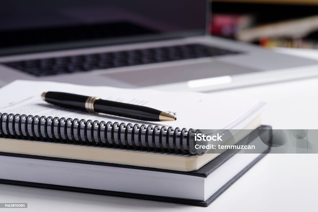 Close up of notebook and  laptop computer Note Pad Stock Photo