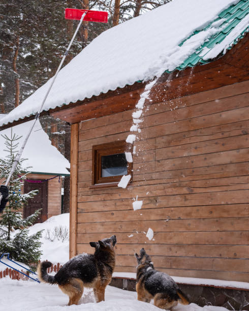 istock Cleaning roof from snow with shovel. 1463810940