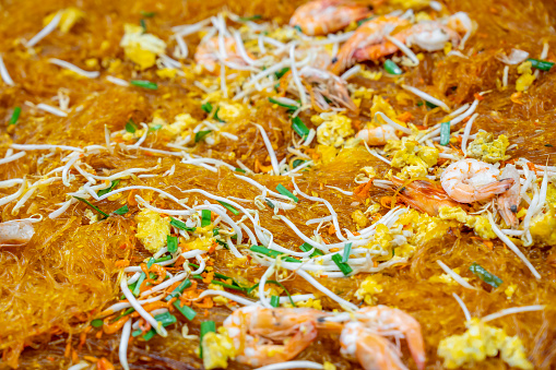 'Pad Thai', is a street food meal throughout Thailand. Here the ingredients are being stir fried in a large wok or metal hot plate.