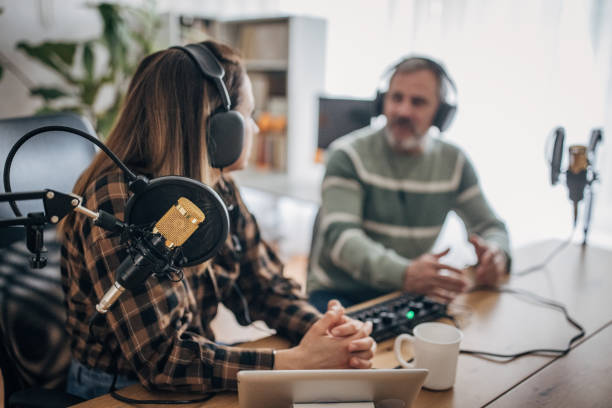 istock Two people are recording a podcast and talking into microphones 1463815490