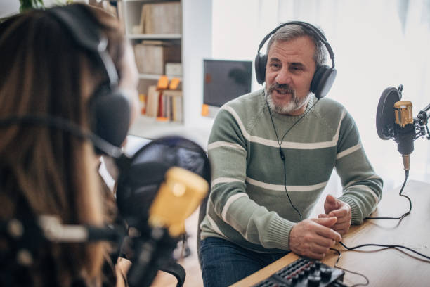 istock Two people are recording a podcast and talking into microphones 1463815623
