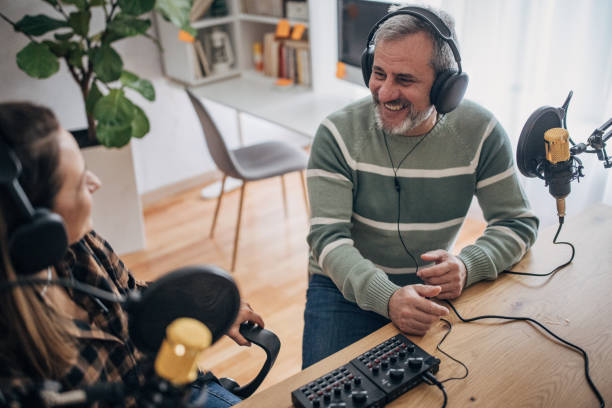 istock Two people are recording a podcast and talking into microphones 1463815630