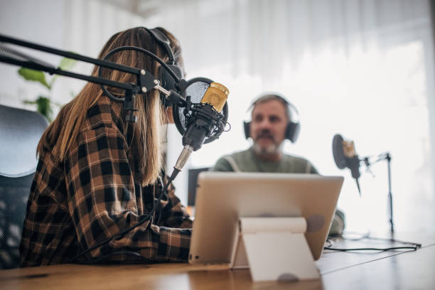 istock Two people are recording a podcast and talking into microphones 1463815673