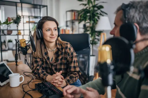 Photo of Podstaker, a young woman makes a podcast in the studio