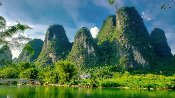 中国の黄山脈を背景にした小さな川。観光地区 - yangshuo ストックフォトと画像