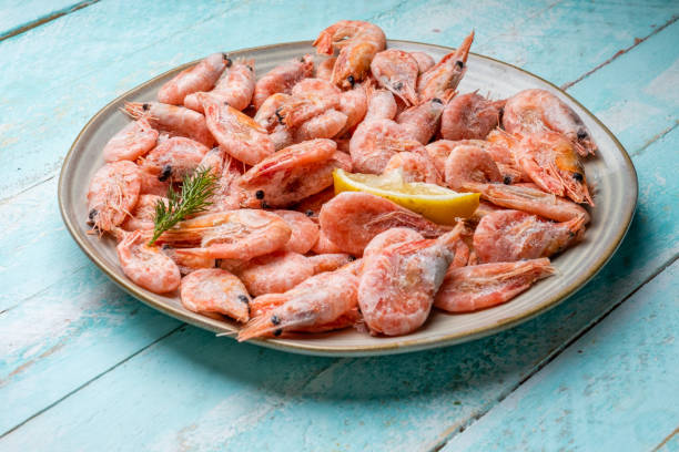 istock Plate with frozen shrimp on a wooden background. 1463817520