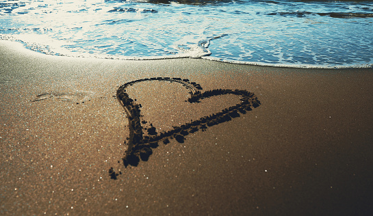 Heart drawn on the sandy sea beach.