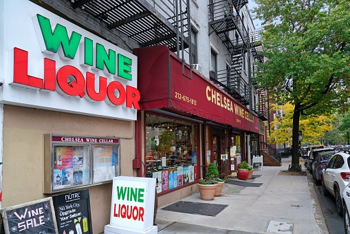 New York, NY - October 24 2022:  Chelsea district of Manhattan,  liquor and wine store in old building, on corner of tree lined street