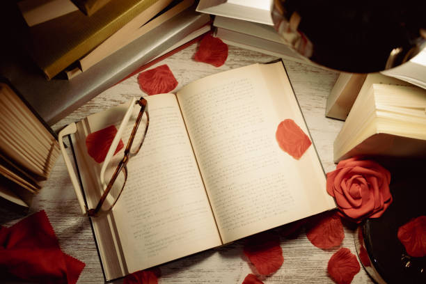 istock table with books, open book with glasses on top and rose petals 1463820450