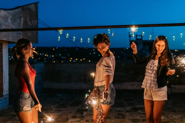 istock Three Female Friends Having A Party On The Rooftop With Sparklers 1463820765