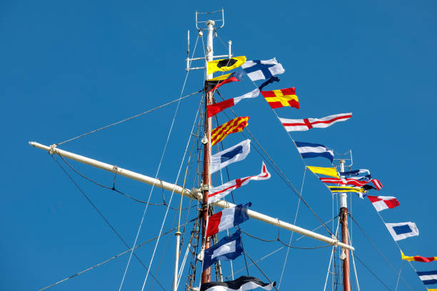 istock International maritime signal flags on a flagpole and masts on a sailing ship with a blue sky in the background. 1463822321