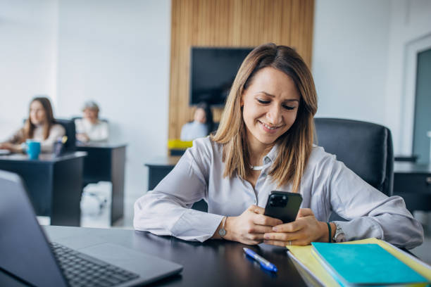 istock Business woman using mobile phone in the office 1463823002