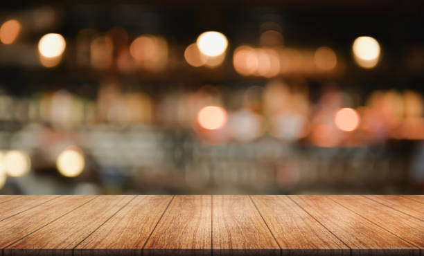 istock Empty wooden table top with lights bokeh on blur restaurant background. 1463823458