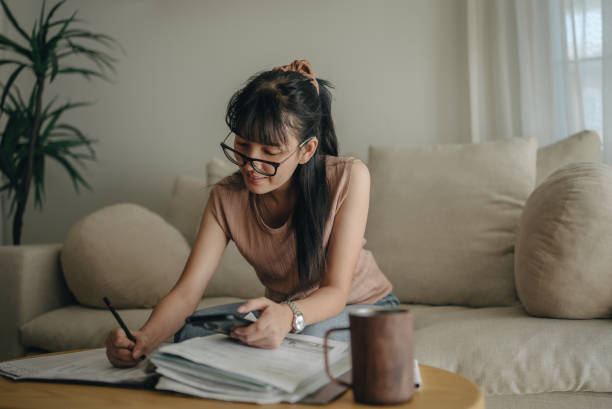 istock Asian woman planning budget and using calculator on smartphone. 1463823537