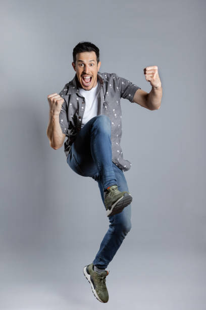 istock Happy Man jumps with casual clothes doing winner gesture 1463823617