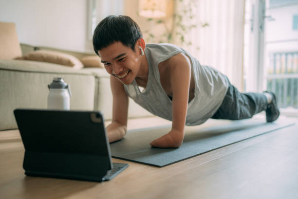istock Young man with arm disabilities exercising at home. 1463823639