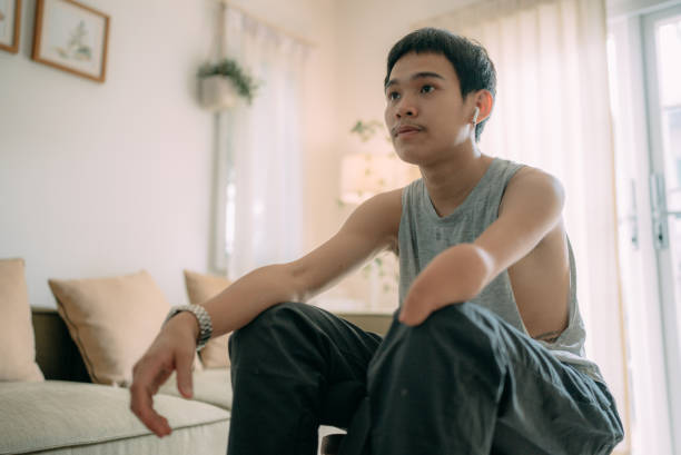 Portrait of a fit young man in sportswear drinking from a water bottle during a break from a home workout session