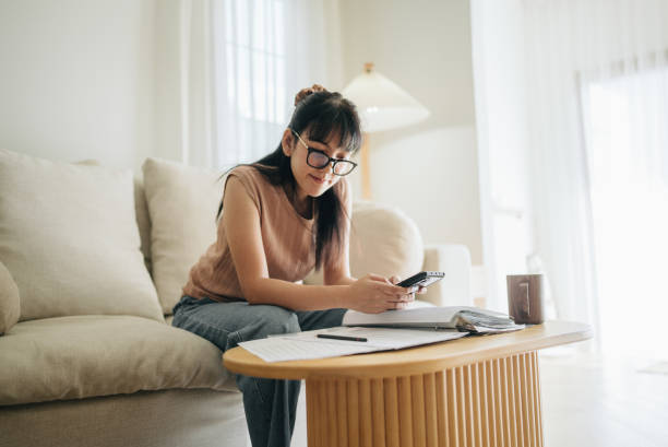 istock Asian woman planning budget and using calculator on smartphone. 1463823937