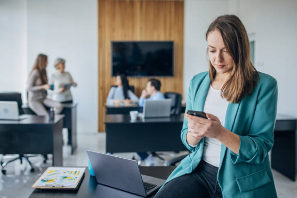 istock Business woman using mobile phone in the office 1463824117