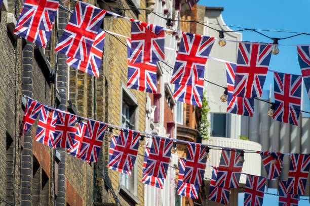 guirlandes de drapeaux de l’union jack britannique dans une rue de londres, royaume-uni - british flag photos et images de collection