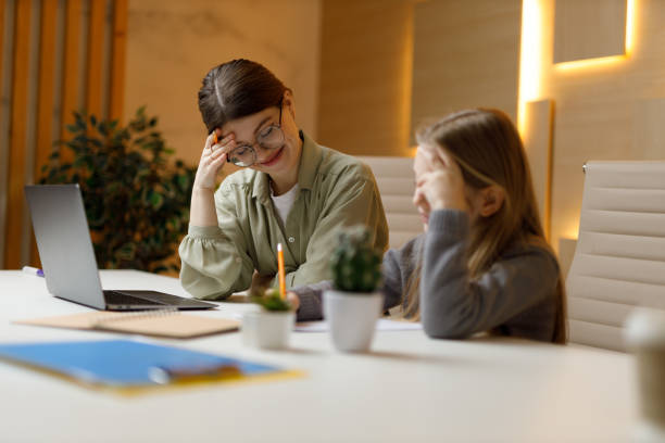 istock Difficulties in learning, a young teacher and a student at the table, misunderstanding. 1463825671