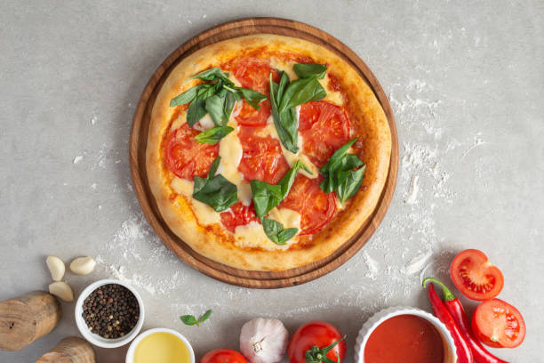 istock The process of making margarita pizza. Male hands, top view. Tomato paste with cheese. 1463826814