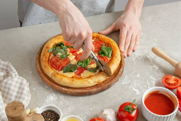 istock The process of making margarita pizza. Male hands, top view. Tomato paste with cheese. 1463827505