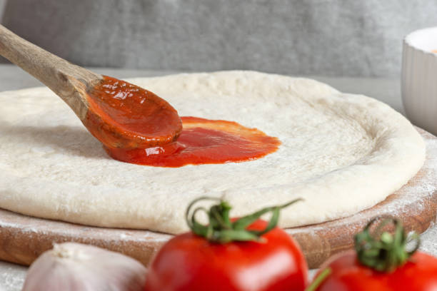 istock The process of making margarita pizza. Male hands, top view. Tomato paste with cheese. 1463827651
