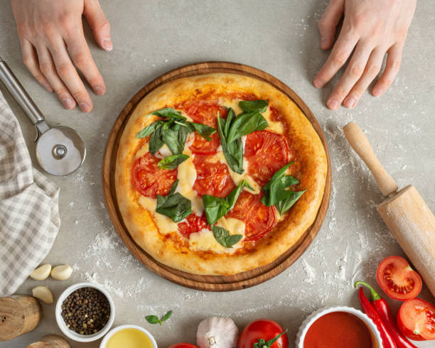 istock The process of making margarita pizza. Male hands, top view. Tomato paste with cheese. 1463828412