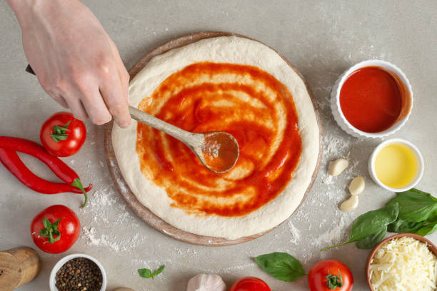 istock The process of making margarita pizza. Male hands, top view. Tomato paste with cheese. 1463828757