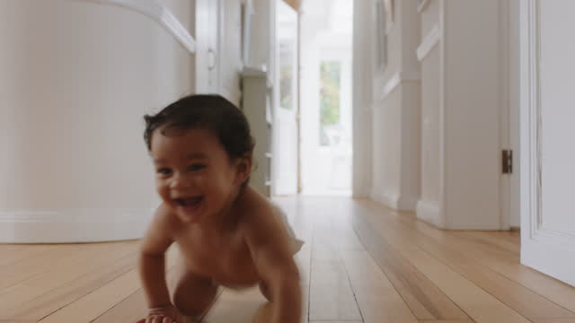 happy baby girl crawling on floor toddler exploring home curious infant having fun enjoying childhood