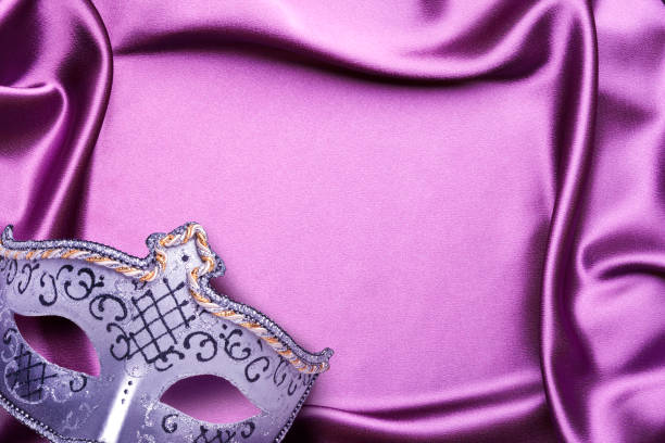 Mardi Gras mask on a purple satin background with elegant folds.
