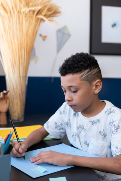 istock Concentrated young boy draws at the table in his room 1463833958