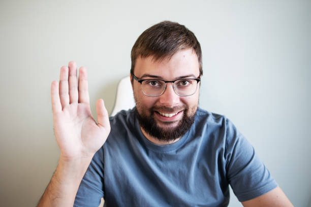 istock Smiling young man smiling while talk on webcam having video callwith her friends on whats app 1463834162