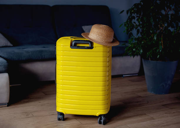 istock Yellow suitcase with hat . travel concept. minimal style 1463834853