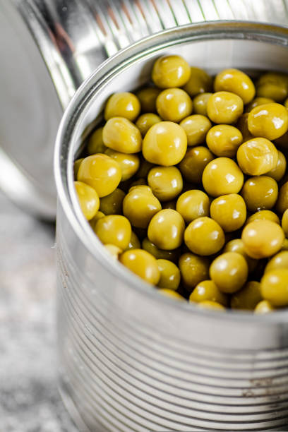 istock Canned green peas in a tin can on the table. 1463835799