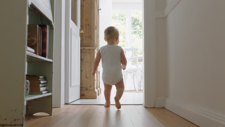 baby boy learning to walk toddler exploring home curious infant walking through house enjoying childhood