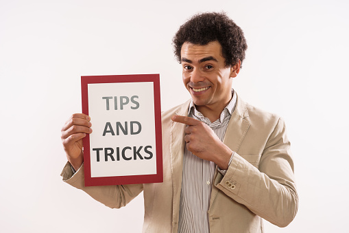 Image of businessman holding paper with text  tips and tricks