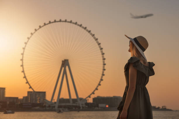 woman enjoying sunset and view to the ferris wheel Ain Dubai. UAE stock photo