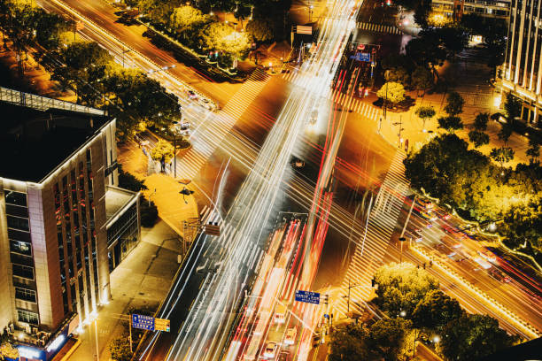vue aérienne nuit intersection ville trafic occupé, scène nocturne de la ville moderne - traffic blurred motion multiple lane highway night photos et images de collection