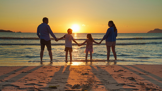 Young family on vacation have a lot of fun at sunset by the sea