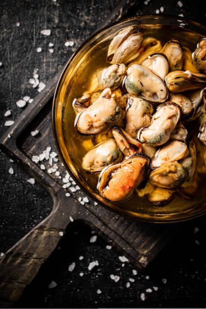 istock Bowl with pickled mussels on a cutting board. Top view. 1463842593