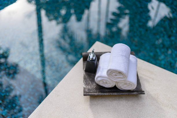 Concept Spa : Spa set Towels with bottle cream pump Placed by the pool Concept Spa : Spa set Towels with bottle cream pump Placed by the pool grooming product stock pictures, royalty-free photos & images