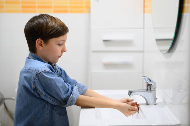 istock Child turns on water faucet in a restroom 1463847954