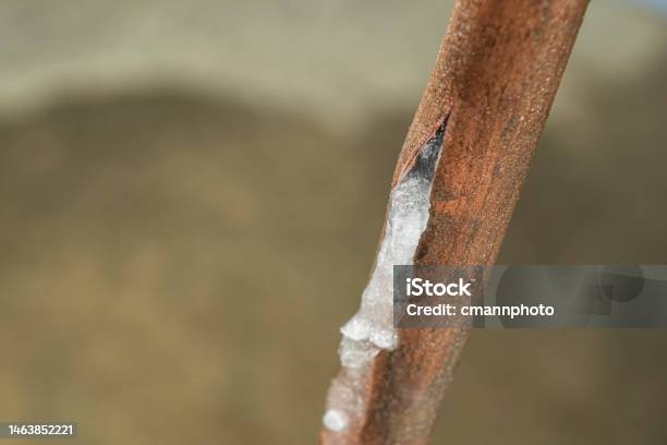 Looking Down On A Ruptured Frozen Copper Water Line With A Puddle On The Basement Floor Stock Photo - Download Image Now