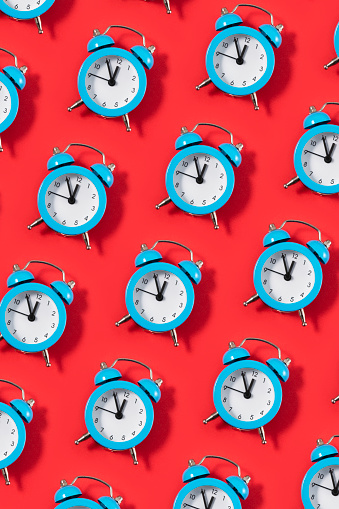 Blue alarm clock on red background