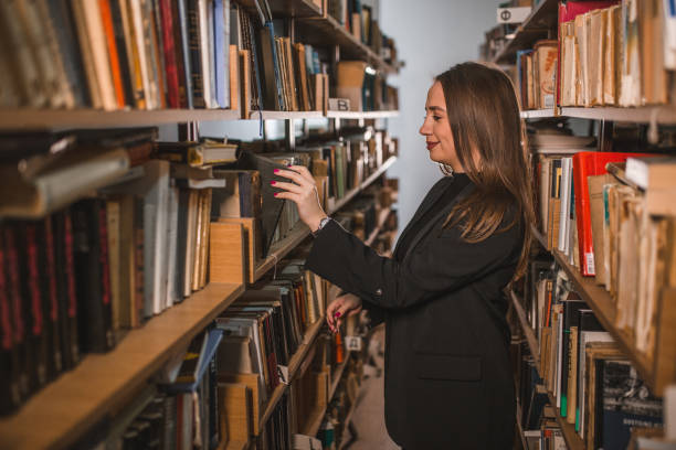 istock A smiling librarian takes a book from the shelf 1463855986