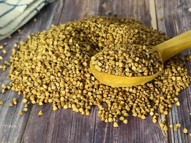 istock Raw buckwheat in a wooden spoon on a wooden surface 1463856251
